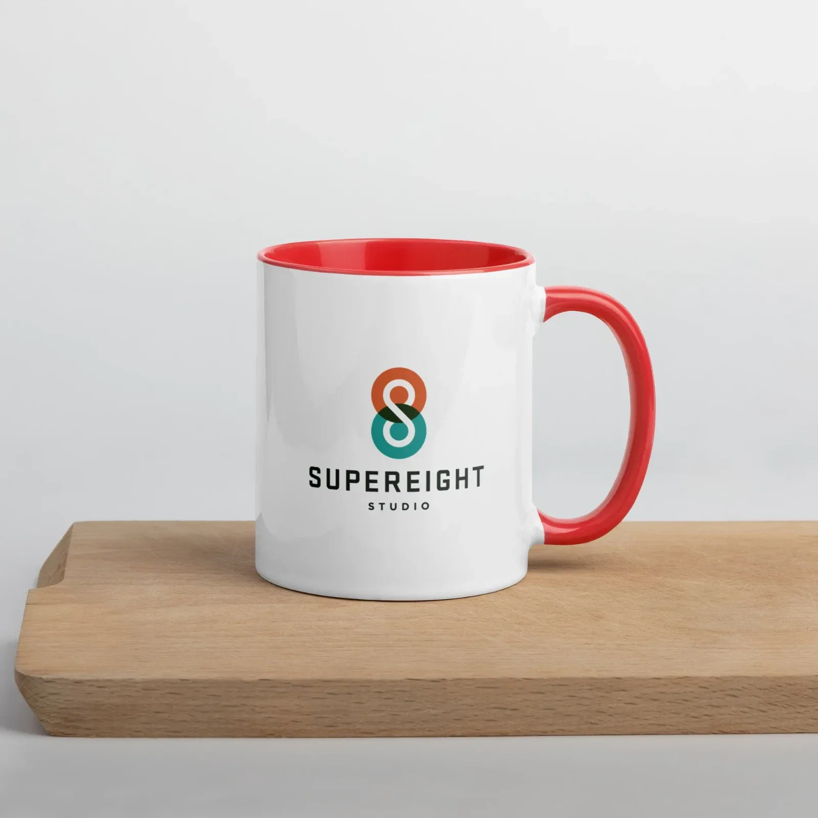 A white Supereight Studio mug with a red handle and inside